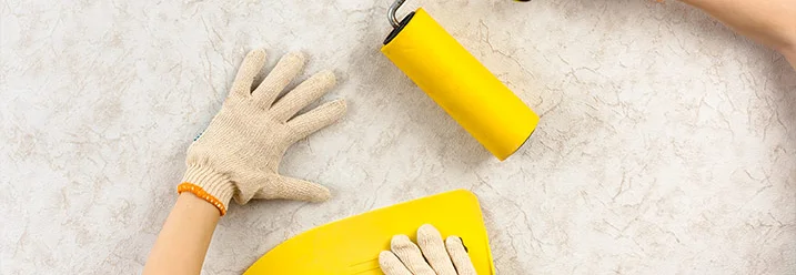 Hände mit Tapezierspachtel und Walze